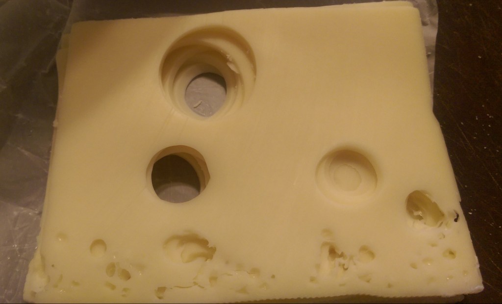 Stack of Swiss cheese slices showing holes lined up.