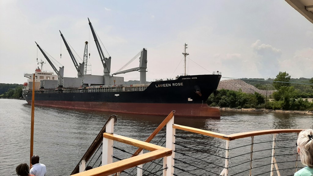 Bulk cargo ship with 3 of 4 cranes in operation, loading scrap