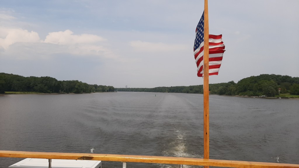 Image is of the Hudson, with the Corning tower a speck in the background. Boat ensign in the foreground.