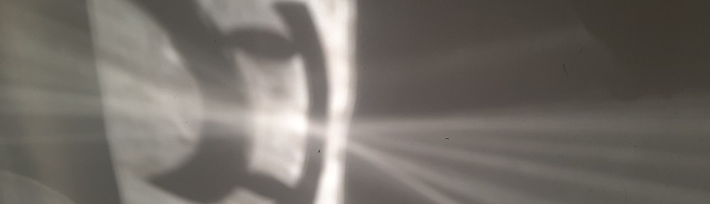Image shows a shadow of a curved handle on a shower door, overlaid with reflection of rays emanating from a point