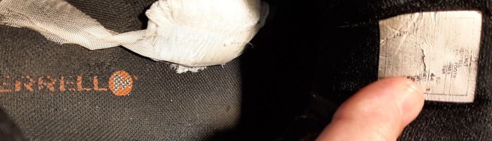 Image shows inside of right shoe with some padding taped in for arch support.