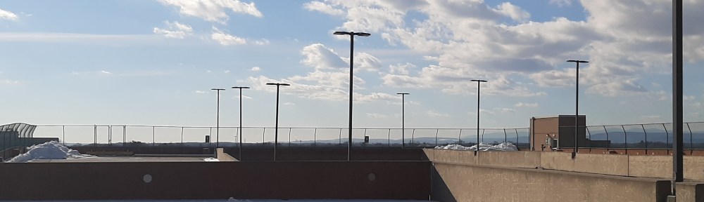 View over the top of a parking garage to mountains in the distance.