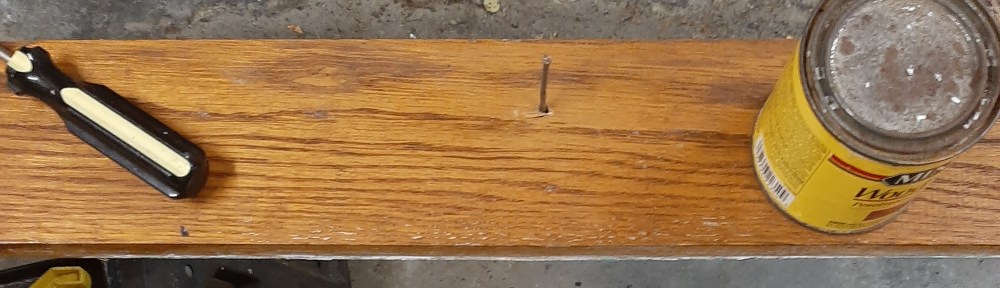 A board on sawhorses with a can of poly on one.